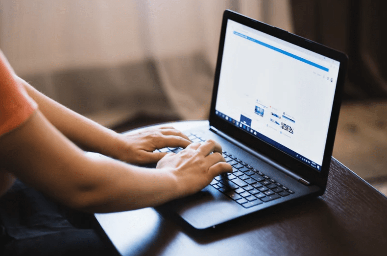 hands typing laptop