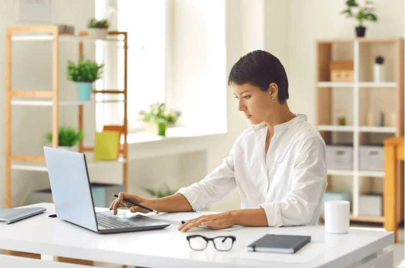 woman in white shirt on laptop